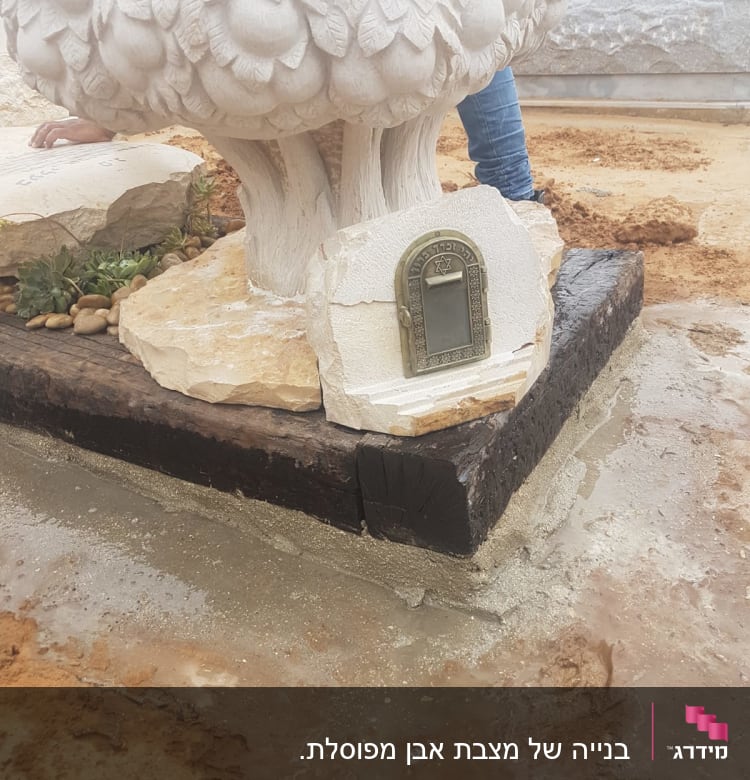 מצבה עם עיטור עלים ואבן זיכרון קטנה